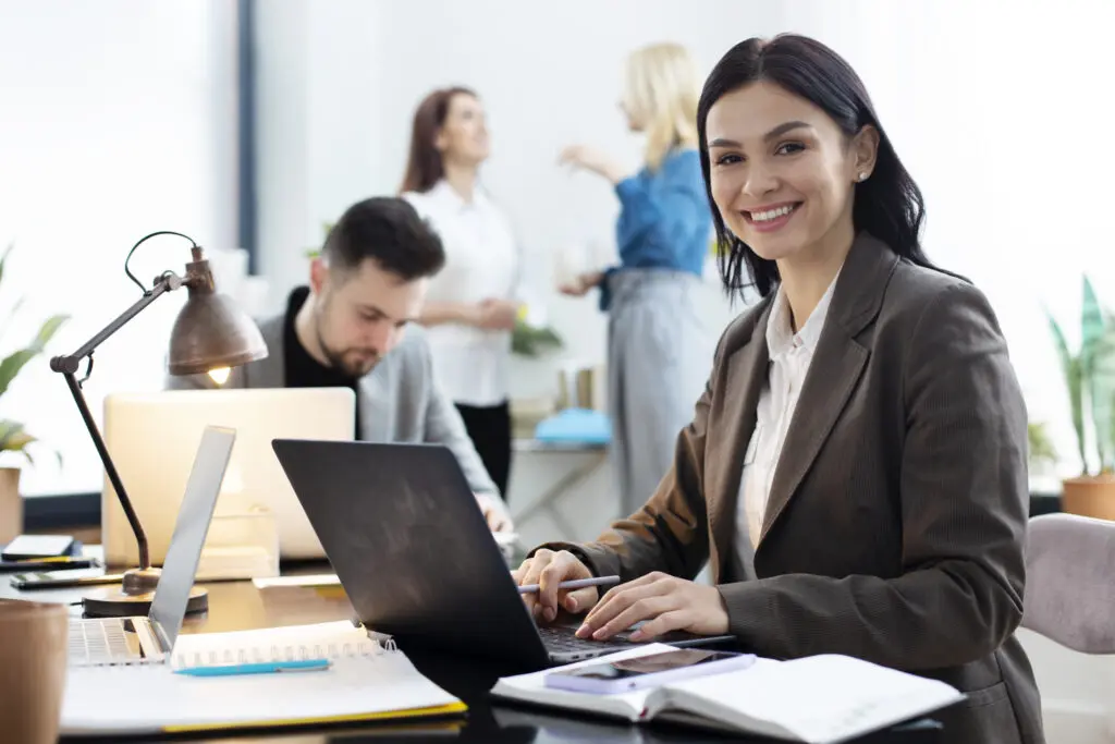 Mulher sorrindo ao usar sistema ERP no notebook