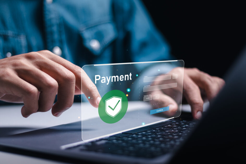 Pessoa usando laptop para gerenciar contas a pagar em painel online, com foco em segurança e validação de transações financeiras.
